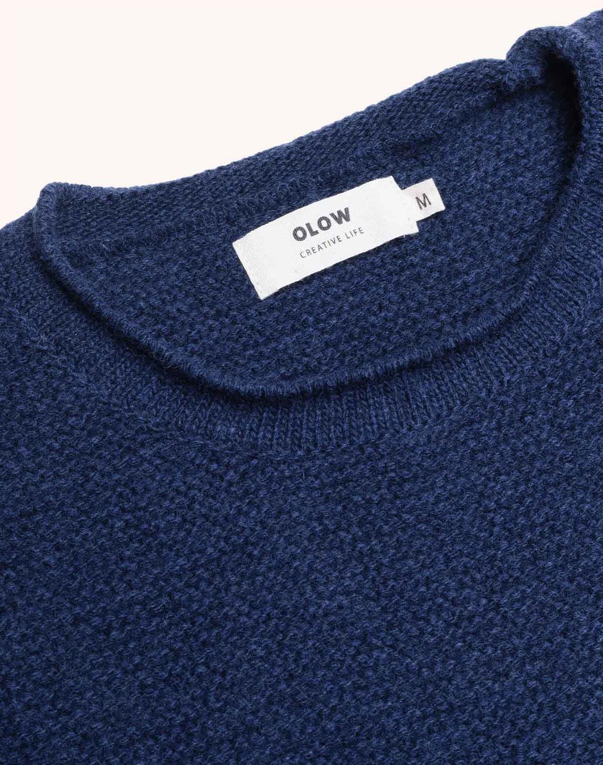OLOW Lesco Merinowollpullover in Dunkelblau – Detail von Ausschnitt und Label